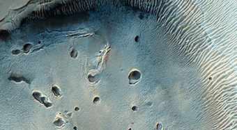 A Dark-Toned, Pitted Mound in a Crater in Northeast Arabia Terra